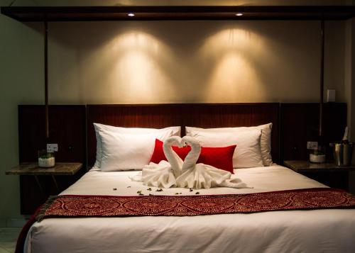 a bed with two swans made out of pillows at APS Guesthouse in Windhoek