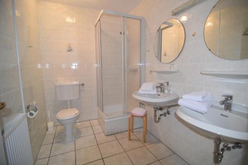 a bathroom with a shower and a toilet and a sink at Gasthaus Deutsches Haus garni in Wunstorf