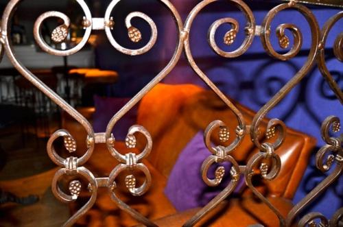 a close up of a metal fence with a bed at Hôtel 19'Cent in Le Creusot