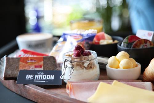 Gennep的住宿－Hotel De Kroon Gennep，装有一罐冰淇淋和水果的食品托盘