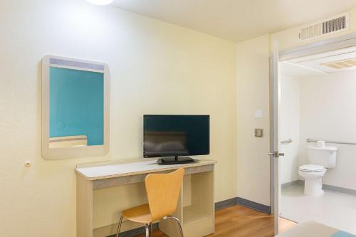 a room with a desk with a monitor and a chair at Motel 6 Fredericksburg, Va - North in Fredericksburg