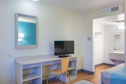 a room with a desk with a television and a bed at Motel 6 Fredericksburg, Va - North in Fredericksburg