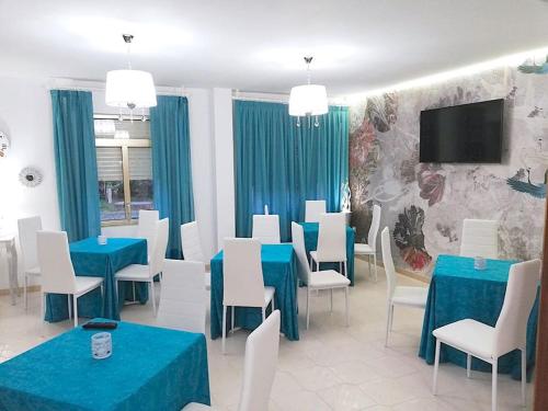 uma sala de jantar com mesas azuis e cadeiras brancas em A Casa De Amparo em Sanxenxo