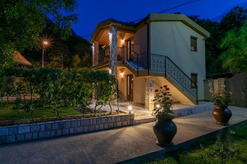 a villa with a house at night at Ethno Lodge AB in Virpazar