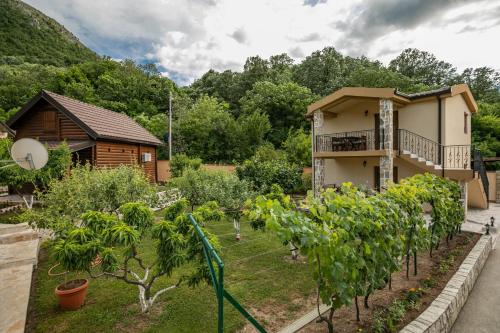 a garden in front of a house with trees at Ethno Lodge AB in Virpazar