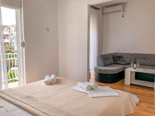 a white room with a bed with towels on it at Vila Adriatik in Ulcinj
