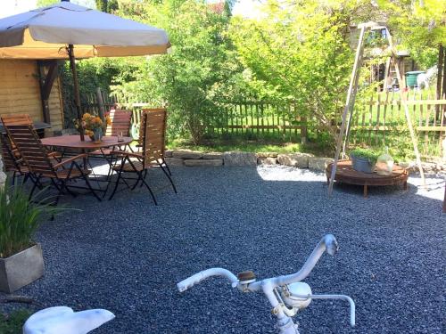 a bike parked in a yard with a table and an umbrella at BIO Kastanienhof Erfurt - Appartements und ayurvedische Jurten in Erfurt