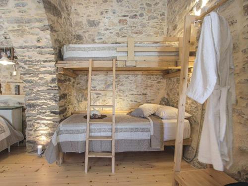two bunk beds in a room with stone walls at Azura, traditional residence in Ano Syros in Ano Syros