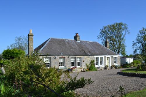 una antigua casa de piedra con techo gris en Balmungo Cottage B&B en St Andrews