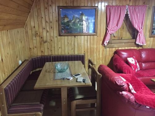 a living room with a table and a couch at Golija Vikendica Česta Vrela in Raška