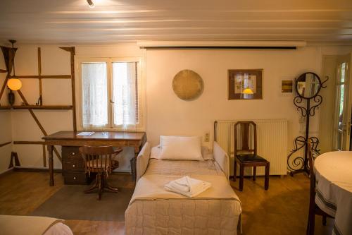 a bedroom with a desk and a bed and a table at Lefkada Town Traditional House / Cozy Yard in Lefkada Town
