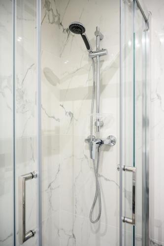 une douche dans une salle de bain avec une porte vitrée dans l'établissement 2 GUISOL - Moderne 2 pieces Port de Nice, à Nice