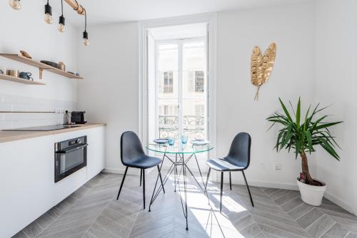 une cuisine avec une table en verre et deux chaises dans l'établissement 26 MASSENA - Moderne 2 pieces - ZONE PIETONNE, à Nice