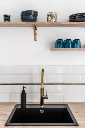 - une cuisine avec un évier et une étagère avec de la vaisselle dans l'établissement 26 MASSENA - Moderne 2 pieces - ZONE PIETONNE, à Nice