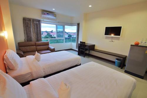 a hotel room with two beds and a flat screen tv at Panwalee Hotel in Khon Kaen
