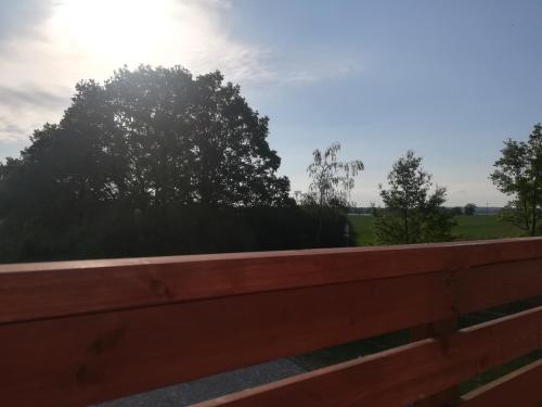 a wooden fence with trees in the background at Apartmán Life in Nature in Jaronice