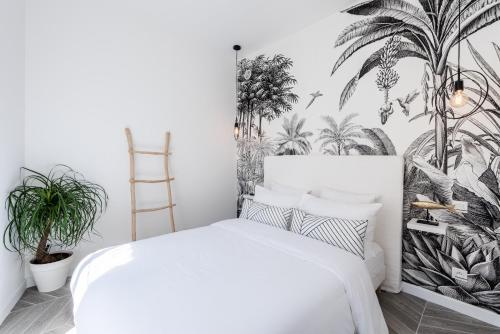 - une chambre dotée d'un lit blanc et d'une fresque murale sur les palmiers dans l'établissement 26 MASSENA - Moderne 2 pieces - ZONE PIETONNE, à Nice