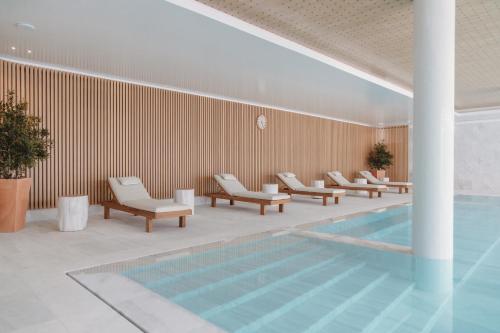 a pool with lounge chairs next to a swimming pool at Praia do Sal Resort in Alcochete