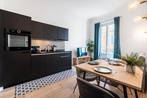 Il comprend une cuisine et une salle à manger avec une table en bois. dans l'établissement 12 CONGRES APT3 - Appartement Belles Prestations - Carre d'Or - Clim, à Nice