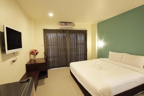 um quarto de hotel com uma cama e uma televisão em Panwalee Hotel em Khon Kaen