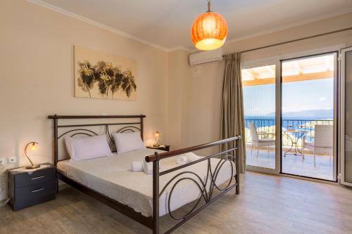 a bedroom with a bed and a balcony at Villa Kallisti in Meganisi