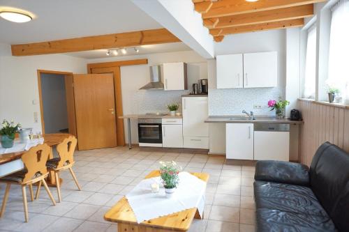 een keuken en een woonkamer met een bank en een tafel bij Kurparkhotel Faißt in Bad Peterstal-Griesbach