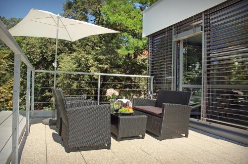 a patio with a table and chairs and an umbrella at Atelier Lanna in České Budějovice