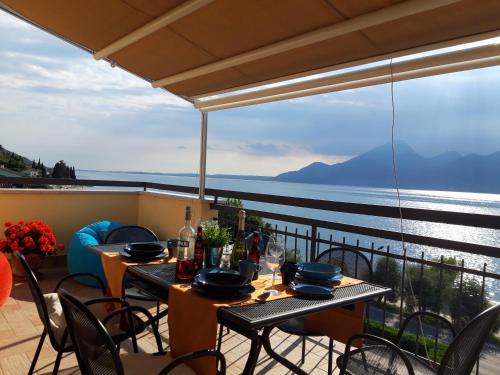a table on a balcony with a view of the water at Penthouse CASA ALKEA Masse Lake view in Brenzone sul Garda