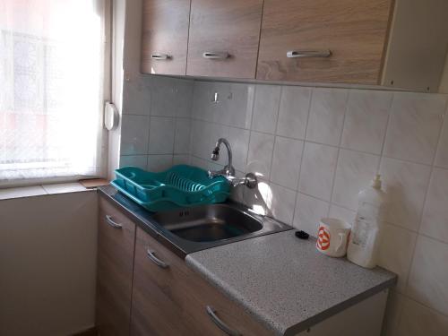 a kitchen sink with a green tray on it at Napsugar Nyaraló in Fonyód