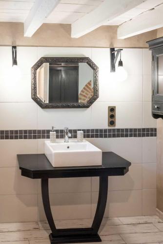 une salle de bain avec un lavabo et un miroir au mur dans l'établissement au Mas de Garet - Chambre d'hotes de Charme, à Pinsac