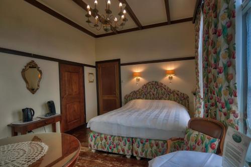 a bedroom with a bed and a table in a room at Hotel Pension 't Huys Grol in Renesse