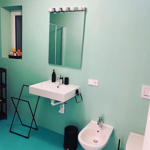 a bathroom with a white sink and a mirror at Casa sciliar blu centro paese in Völs am Schlern