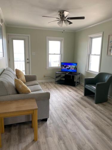 a living room with a couch and a flat screen tv at Rio Motel and Suites Wildwood Beach & Boardwalk in Wildwood