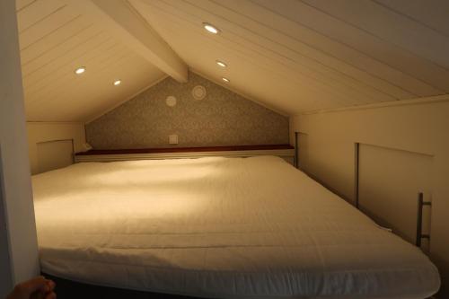 Cette petite chambre comprend un grand lit blanc. dans l'établissement Ångsågen, à Skärblacka