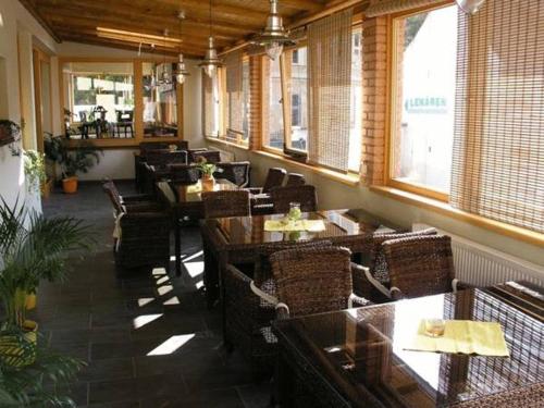 a restaurant with wooden tables and chairs and windows at Penzion Beryl in Košice