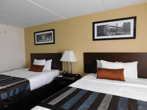 a hotel room with two beds and a lamp at Wingate by Wyndham Bowling Green in Bowling Green