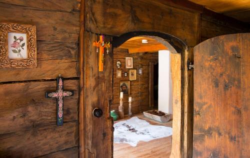 an open door to a room with a cross on the wall at Speckbacher Hof - Historisches Bauernhaus im Chiemgau in Unterwössen