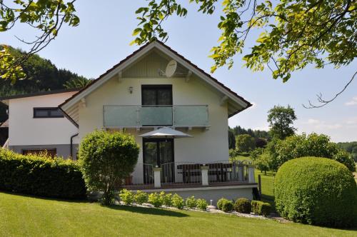 a white house with a green yard at Das Ferienhaus in Attersee am Attersee