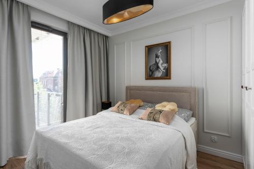 um quarto com uma cama branca e uma janela em Modernico-Gdańsk Old Town em Gdansk