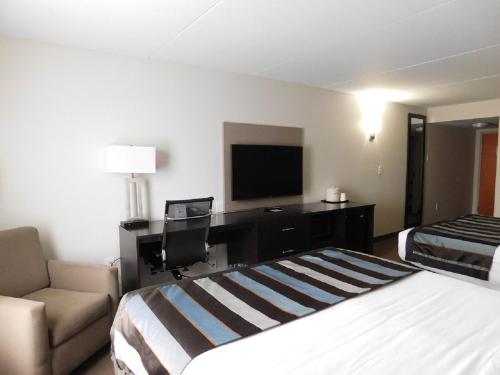 a hotel room with a bed and a desk at Wingate by Wyndham Bowling Green in Bowling Green