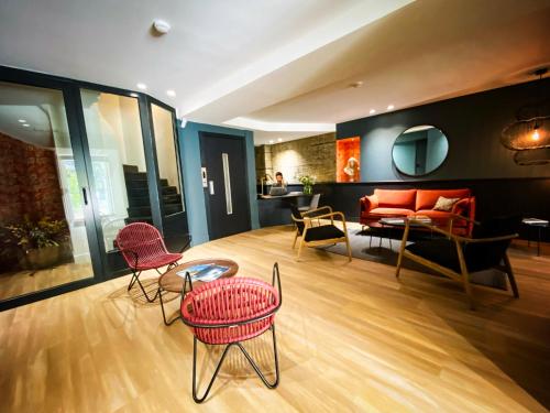 a living room with red chairs and a couch at Hotel Molière in Cannes