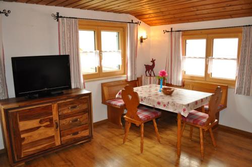 a dining room with a table and a television at Ferienwohnung Baumgartner in Bad Hindelang