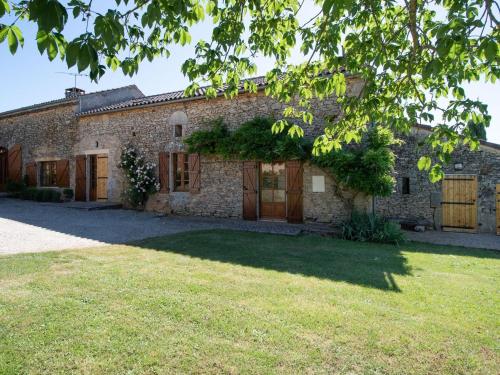 an old stone house with wooden doors and a yard at Spacious Holiday Home in Sauveterre de l mance in Sauveterre-la-Lémance