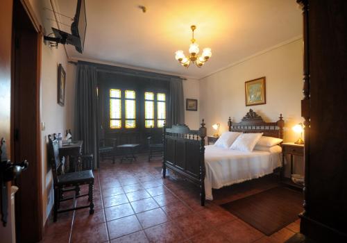 1 dormitorio con 1 cama, mesa y sillas en Hotel Mar de Queo, en Carballo