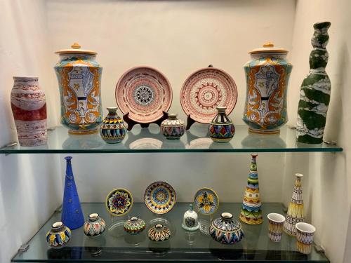 a bunch of vases and plates on a shelf at Hotel Bonazzi in Perugia