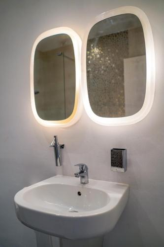 a bathroom with a sink and two mirrors at Obzor Tatyana Apartaments Art in Obzor