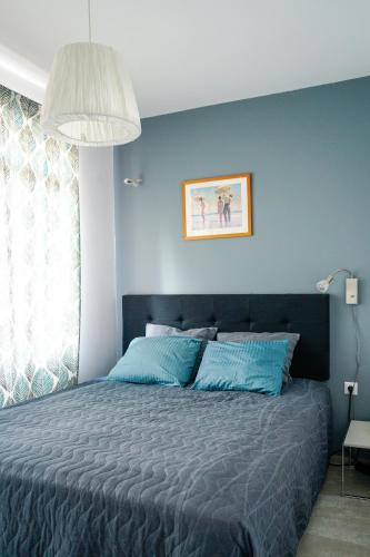 a bedroom with a bed with a blue wall at Obzor Tatyana Apartaments Art in Obzor