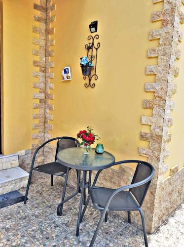 a table with two chairs and a table with flowers on it at Nicole Luxury Villas in Koskinou