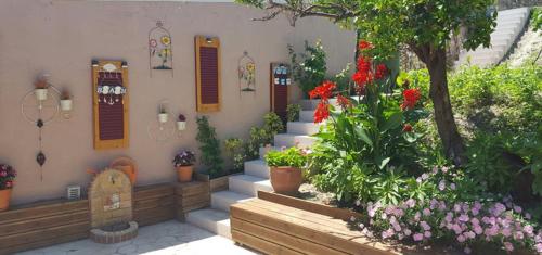 a garden with flowers and plants in front of a building at Philoxenia Home in Áyios Pétros
