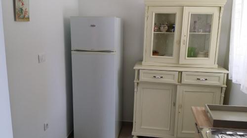 kuchnia z białą lodówką i szafką w obiekcie House Mergi 2 w mieście Pomer